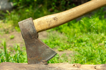 An ax sticking out of a log. Preparation of firewood.