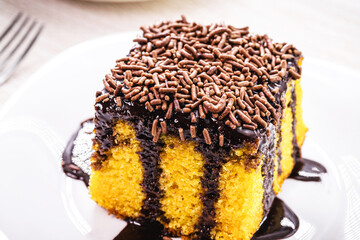 carrot cake with chocolate sprinkles, creamy frosting dripping over the cake, typical Brazilian sweet at June parties
