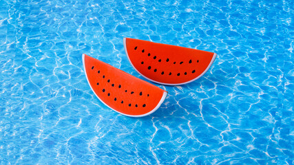 Two slices of plastic watermelon on artificial sea background. Minimal creative concept for summer leisure holidays. Design for travel agency banner