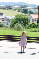 Fototapeta na wymiar Little girl having fun on swing