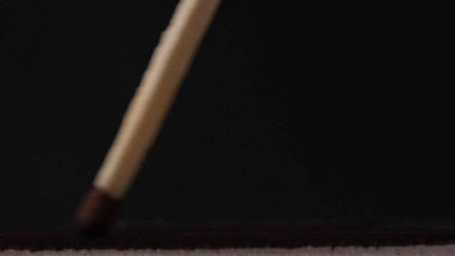 Light a match in the dark, closeup. Strike a matchstick