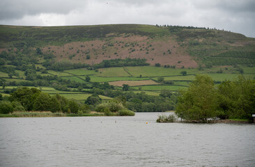 lake with a wooded island and adventure park for water sports, mountain background