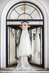 Wedding dress hanging on the door in the white room