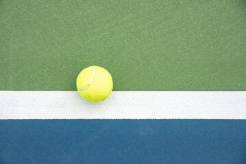 Top view of a tennis ball hitting outside the line of the doubles sideline on a court. - obrazy, fototapety, plakaty