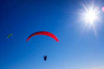Paragliders glide through the air by launching themselves from high mountains with special parachutes.