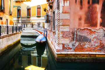 Fototapeta na wymiar Boat moored between colorful houses. Canals in Venice, Italy
