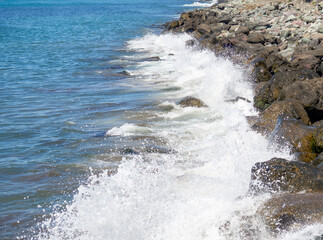  Waves crash on big rocks. Rocky coast and wave. Powerful coastline. Sea foam. The excitement of the sea. Huge coastal rocks.