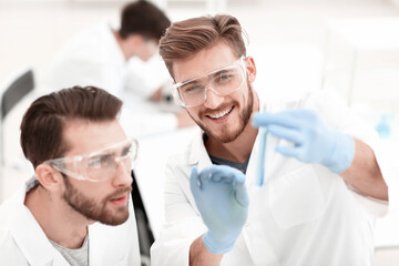 Obraz na płótnie Canvas two biologist examining liquid in a test tube