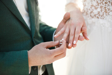 Obraz na płótnie Canvas Groom wears ring on bride's finger