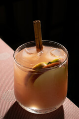 apple, cinnamon and guava flavored cocktail with a black background