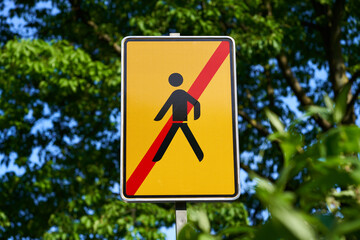 Traffic sign with the information that the detour for pedestrians has come to an end. Yellow road...