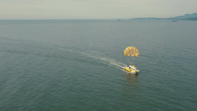 aerial view of Black Sea and wing of skydiving pulled by a boat, Batumi, Georgia. High quality 4k footage