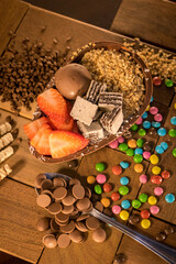 Spoon chocolate egg with paçoca, brigadeiro, granules, floppy disks or confetti, vanilla and chocolate tubes or straws, peanut nuts. strawberry, bonbon, bis, fruit