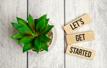 let is got started words on wooden blocks and green plant - obrazy, fototapety, plakaty