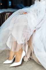 Fototapeta na wymiar Bride putting on her white wedding shoes
