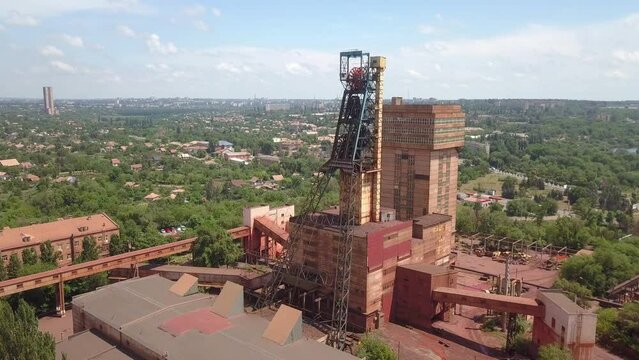 Iron ore mining in the city center. Red mine in the city. Extraction of jelly ore by underground method. Drone aerial high angle view panning.