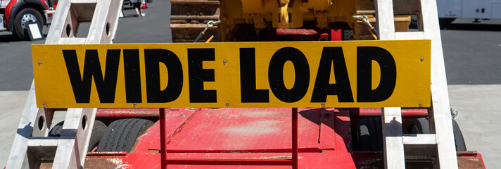 Yellow and black wide load sign on the back of a trailer