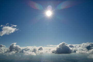 Aerial view from airplane window at high altitude of earth covered with puffy cumulus clouds...