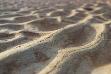 Fototapeta na wymiar sand that forms waves, due to waves of water currents. natural background