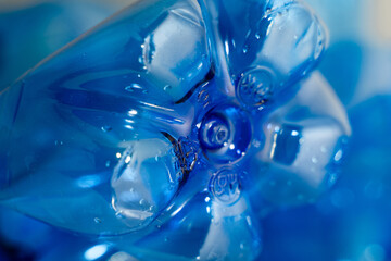 Blue plastic PET bottle in close up on neutral background.  Focus on details