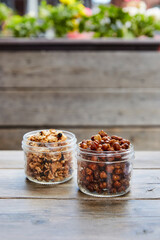 Roasted chickpeas and gronola in jars on a wooden picnic table