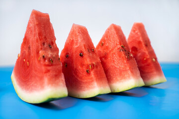 Watermelon cut into slices. Watermelons with green skin colour and red flesh inside on a white background.