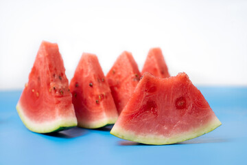 Watermelon cut into slices.  Watermelons with green skin colour and red flesh inside on a white background.