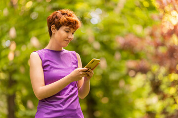 Non-binary gender person using a cellphone in the park