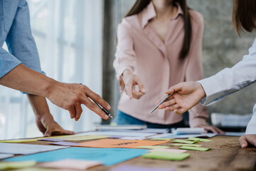 Obraz premium Close up of hands are working on plan drawings, post it, sticky notes, paperworks that show architectural, engineering, marketing, financial and work details.