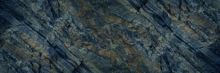 Gray blue brown rock texture. Rough mountain surface with cracks. Close-up. Dark stone background...