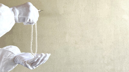 パールのネックレスを持つ白手袋の手_ワイド © smile