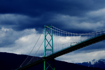 Lions Gate Bridge - suspension bridge between Stanley park and north Vancouver in British Columbia with dramatic clouds in the background