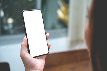 Close up women using a smartphone with an empty white screen at home with window light.