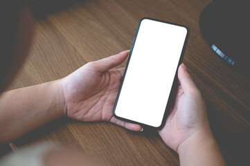 Close up business women using a smartphone with an empty white screen at the office workplace.