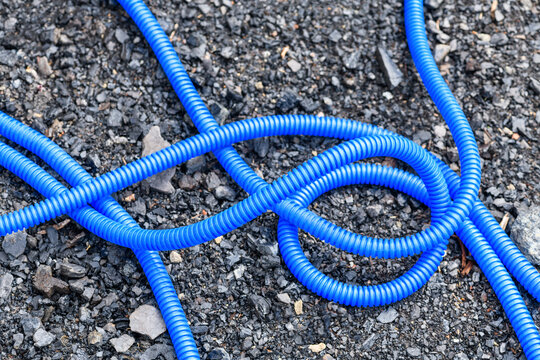 Blue plastic hose for irrigation on the ground