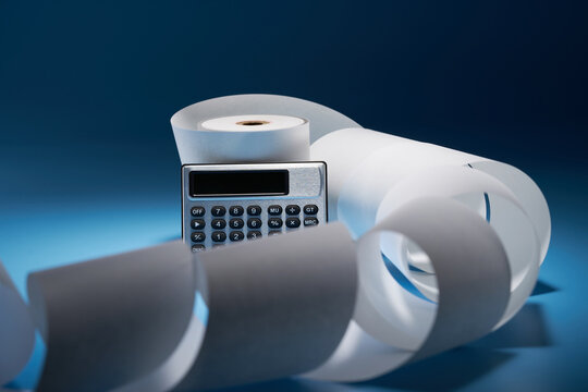 adding machine tape and calculator against blue background
