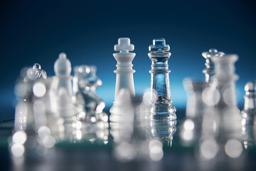 glass chess on the chess board against blue background
