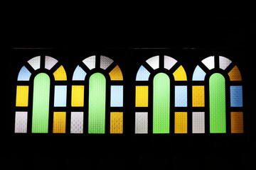Multicolored vintage glass adorned on black window outlines.