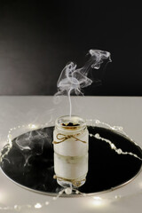 white smoke from an extinguished candle on a black background, reflection