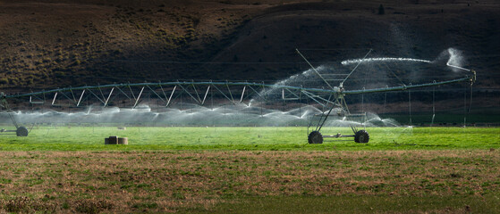 Sprinkler irrigation system at work on a farm pasture in Otago region, South Island, New Zealand