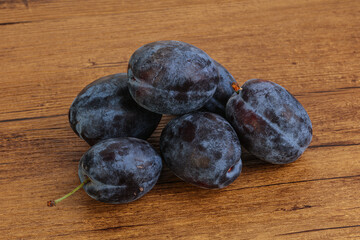 Ripe plum heap over background
