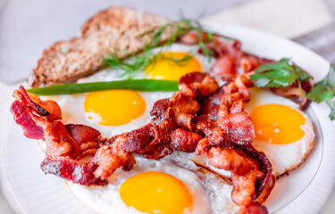 Tasty fried eggs eggs and crispy bacon, close-up, great classic breakfast. Macro photography, shallow depth of field.