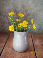 Bouquet of buttercups in a gray glass close-up