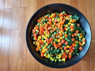 Peas, carrots, corn and spinach vegetarian dish