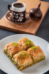 Pistachio baklava on a white plate with Turkish coffee

