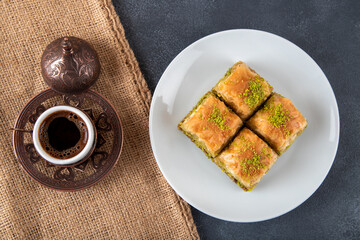 Pistachio baklava on a white plate with Turkish coffee