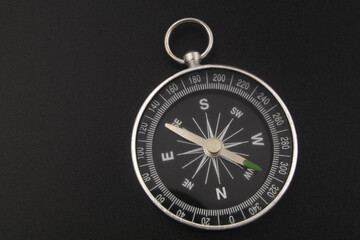 Round compass on black background close-up. Travel, find destination and navigation concept.