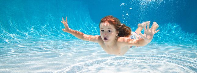 Happy kid swims in pool underwater, active kid swimming under water, playing and having fun,...
