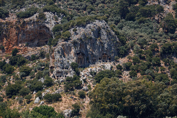 Fototapeta na wymiar Archaeological remains of the Lycian rock cut tombs. Lycian Tombs. Unique ancient necropolis. Ancient Greek burials. Tourism and attractions. River Dalyan, Turkey. Lycian Tombs Of Caunos