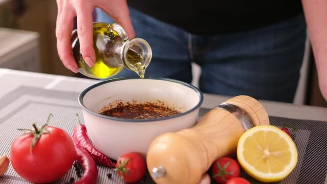 Preparing a marinade sauce for bbq in a domestic kitchen - adding olive oil
